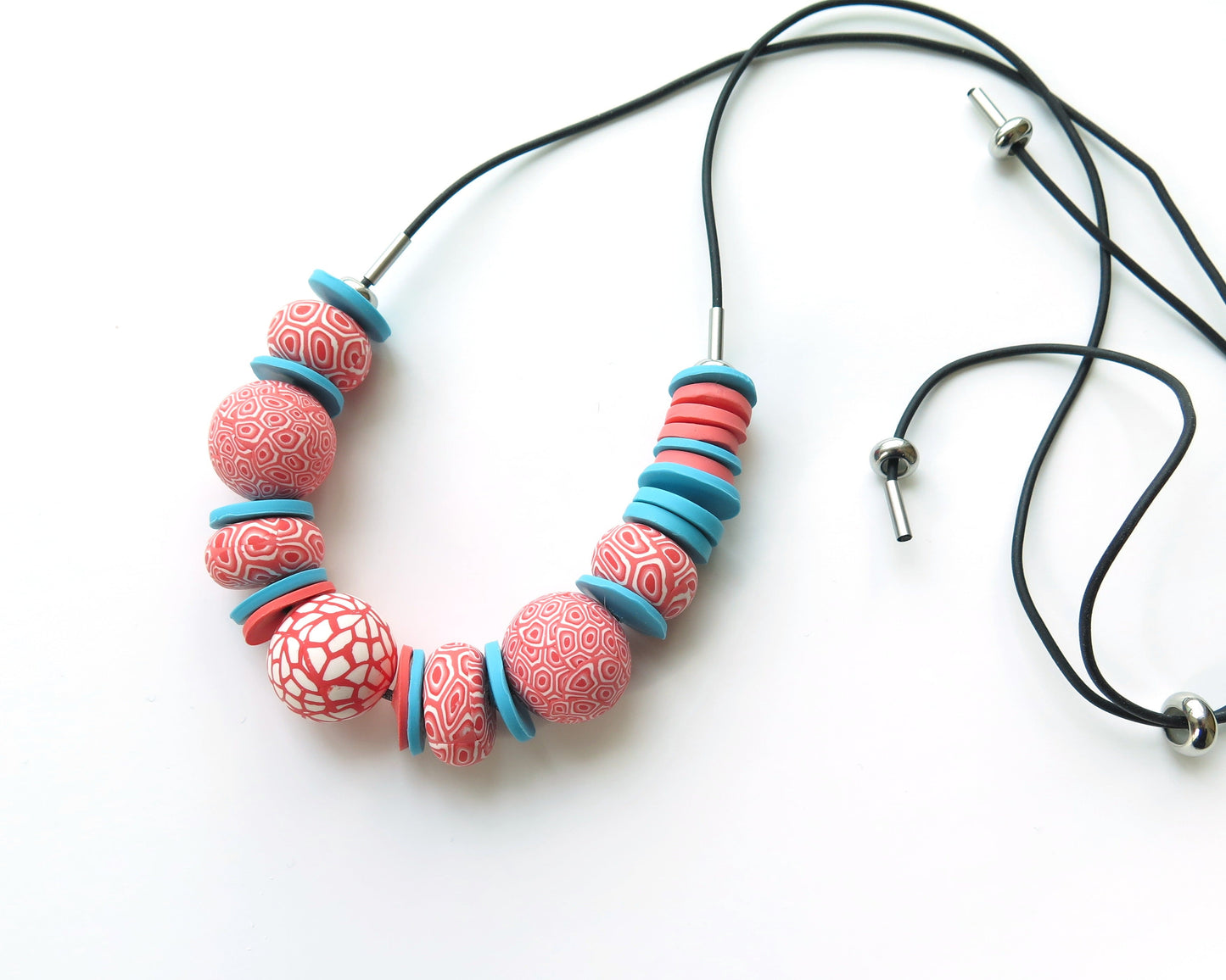 Necklace with coral pink and blue beads on a white background