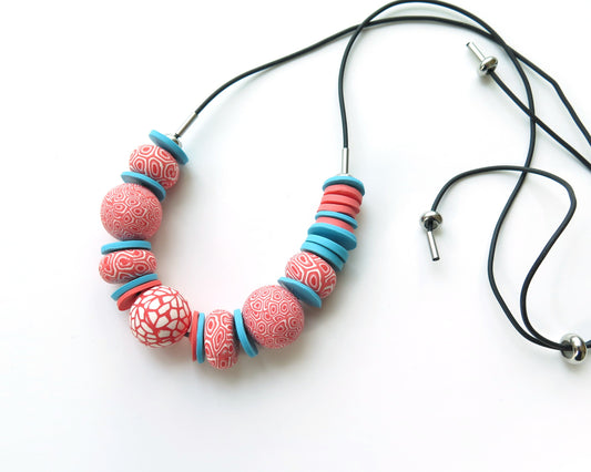 Necklace with coral pink and blue beads on a white background